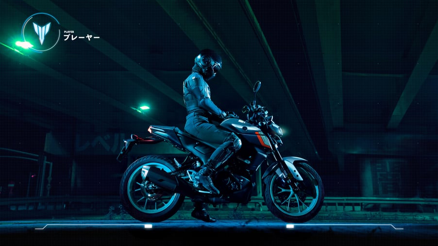 Motorcycle rider in dark warehouse space sat on a Yamaha MT-125